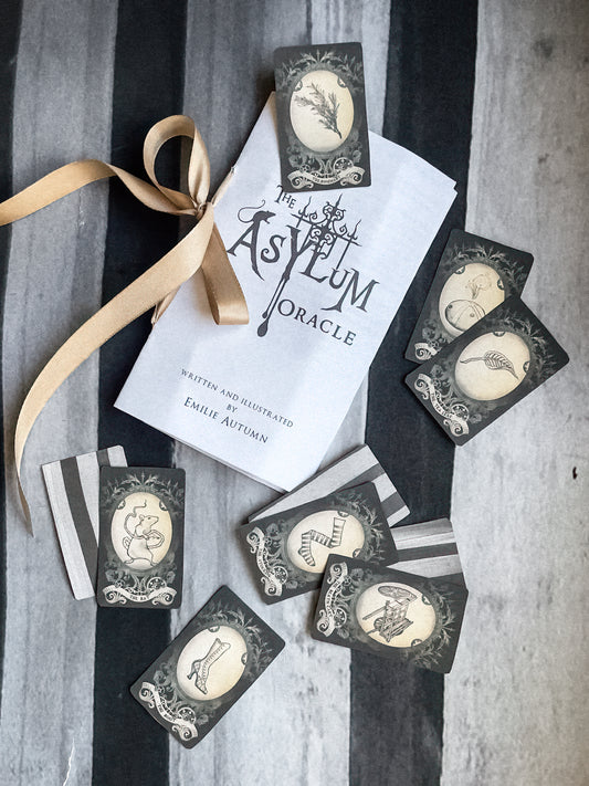 Oracle cards from 'The Asylum Oracle' with a ribbon on a striped background