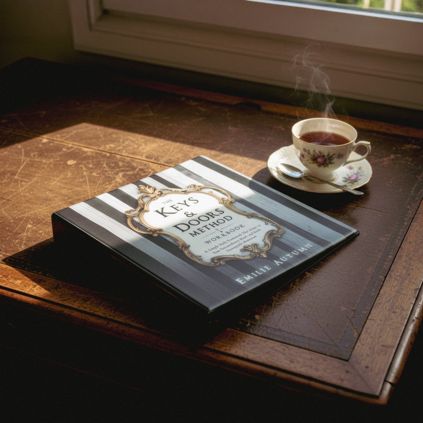 Book titled 'Keys & Doors Method' on a wooden table with a steaming cup of tea.