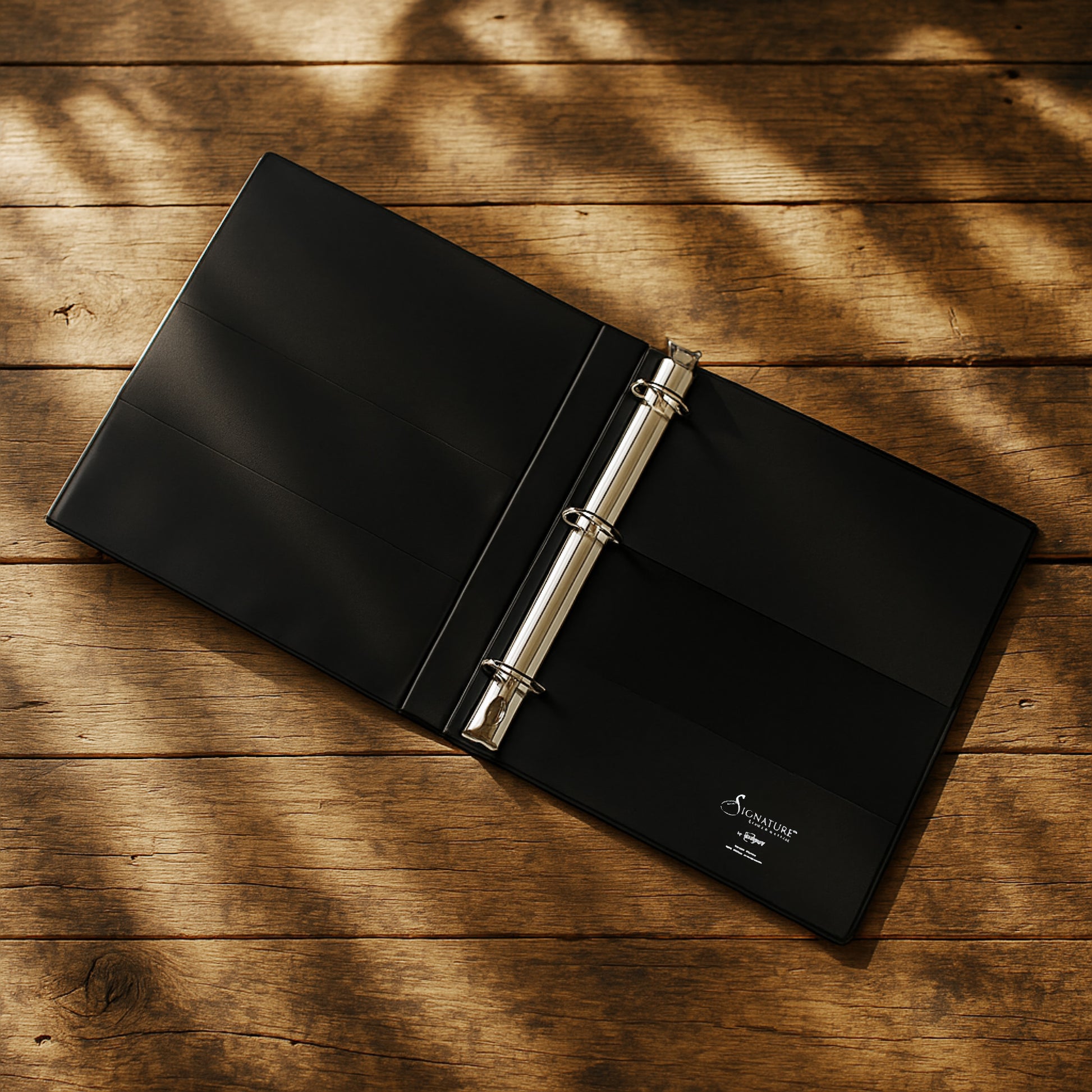Black binder with a silver ring on a wooden surface
